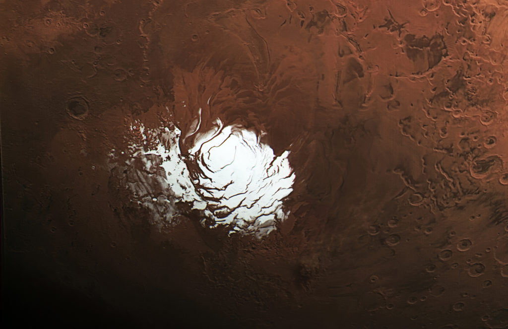 Рис. 1. Вид южной полярной равнины Марса Planum Australe, где радар MARSIS, установленный на аппарате Mars Express, обнаружил первое подледное озеро жидкой воды (показано синим цветом). Изображение: ESA/DLR/FU Berlin, CC BY-SA 3.0 IGO.
